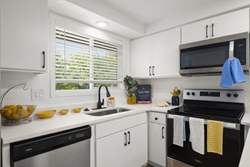 a kitchen with white cabinets and black appliances at Chalet, Springfield, Oregon